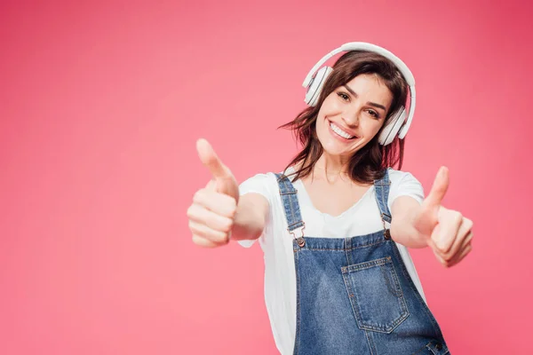 Kobieta Słuchanie Muzyki Słuchawkach Pokazuje Kciuk Górę Różowym Tle — Zdjęcie stockowe