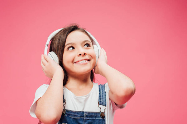Niño Alegre Escuchando Música Tocando Auriculares Aislados Rosa — Foto de Stock
