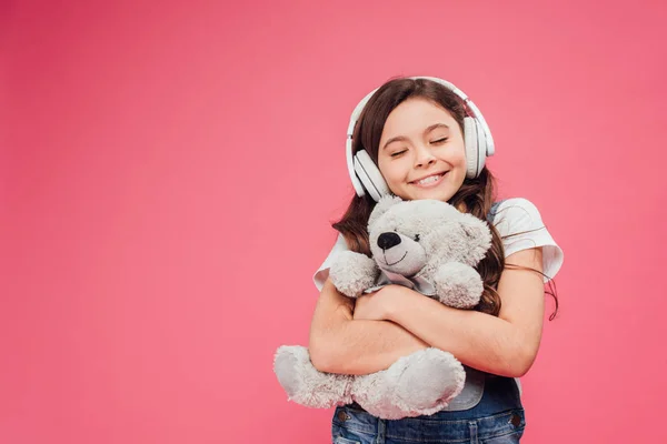 Niño Feliz Auriculares Abrazando Osito Peluche Aislado Rosa — Foto de Stock