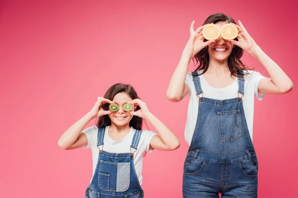 幸福的母亲和女儿拿着水果在眼睛在粉红色隔离 — 图库照片