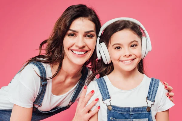 Χαμογελώντας Μητέρα Αγκαλιάζει Κόρη Ακουστικά Που Απομονώνονται Ροζ — Φωτογραφία Αρχείου