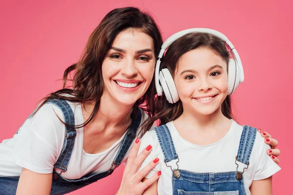 Lachende Knuffelen Moeder Dochter Hoofdtelefoon Geïsoleerd Roze — Stockfoto