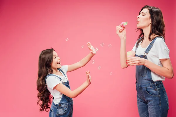 Mother Blowing Soap Bubbles Joyful Daughter Isolated Pink — Stock Photo, Image