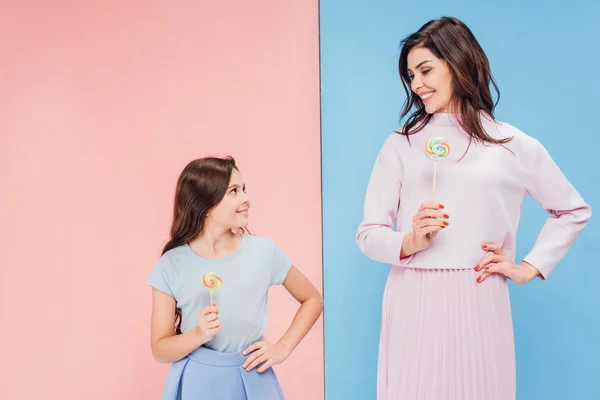 Adorable Niño Atractiva Mujer Sonriendo Sosteniendo Piruletas Sobre Fondo Azul —  Fotos de Stock