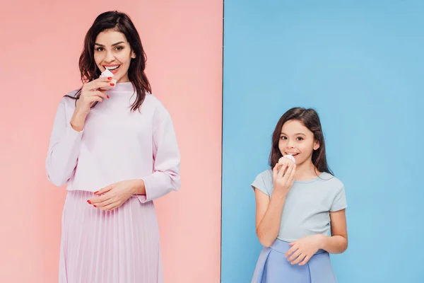 Hermosa Mujer Niño Comiendo Cupcakes Mirando Cámara Sobre Fondo Azul — Foto de Stock