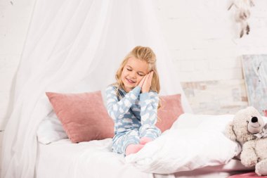 yatakta kapalı gözlerle oturan sevimli uykucu çocuk 