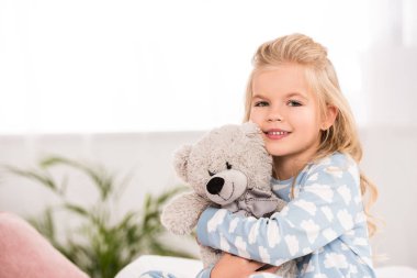 çok güzel çocuk yatak odasında oyuncak ayı sarılma