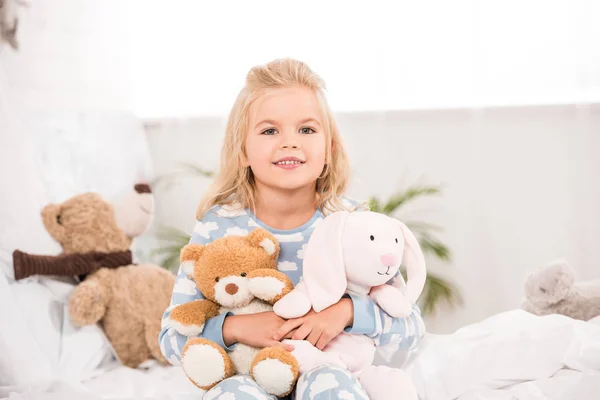 Niño Adorable Sonriente Sentado Con Juguetes Suaves Cama — Foto de Stock