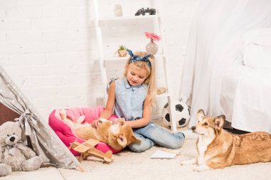 evde Galce corgi köpek ile oynayan sevimli çocuk 