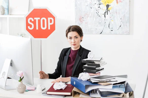 Mulher Negócios Atraente Sentado Mesa Segurando Sinal Parada Escritório — Fotografia de Stock