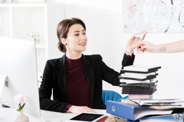 Sekreter ofiste güzel gülümseyen işkadını veren kokteyl