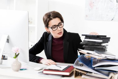 office belgelerinde yığını bakarak bardaklarda çekici iş kadını