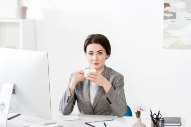 çekici işkadını fincan kahve masasında ve kamera Office bakarak holding