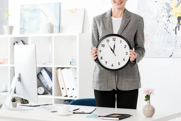 事務所の壁時計を保持している魅力的な実業家のトリミングされた画像 — ストック写真