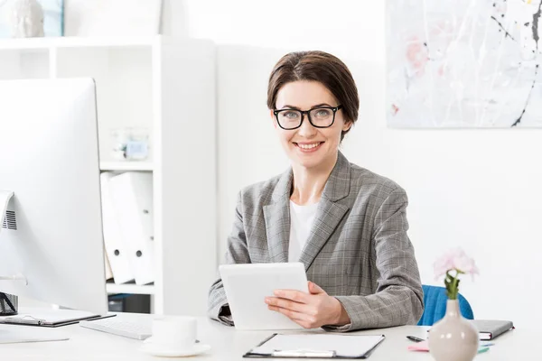 Smiling Attractive Businesswoman Grey Suit Using Tablet Looking Camera Office — Stock Photo, Image