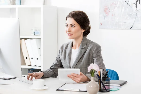 Sonriente Atractiva Mujer Negocios Traje Gris Sosteniendo Tableta Utilizando Ordenador — Foto de Stock