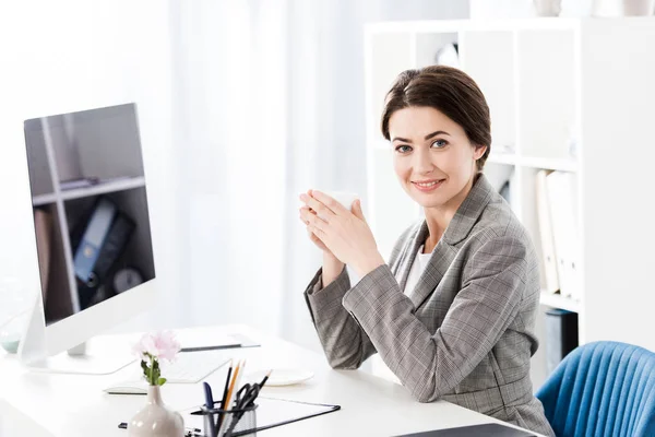 Attractive Businesswoman Grey Suit Holding Cup Coffee Table Looking Camera — Stock Photo, Image