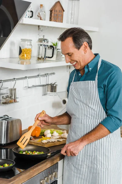 Smiling Handsome Mature Man Cooking Vegetables Frying Pan Kitchen — Stock Photo, Image