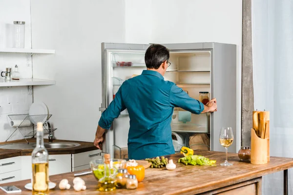 Rückansicht Eines Reifen Mannes Der Den Kühlschrank Der Küche Blickt — Stockfoto