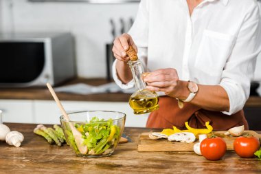 Mutfakta salata bir kase içine olgun kadın boşaltma petrol resim kırpılmış