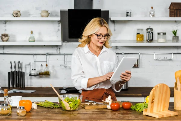 Atractiva Mujer Madura Gafas Lectura Receta Tableta Durante Cocción Cocina — Foto de Stock