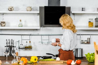 Mutfakta çay tutan orta yaşlı kadın