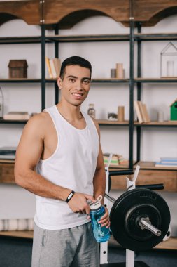 spor şişe tutan ve halter duran neşeli bı ırkçı adam 