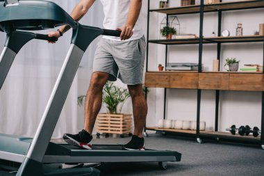 adam egzersiz görünümünü oturma odasında treadmill kırpılmış