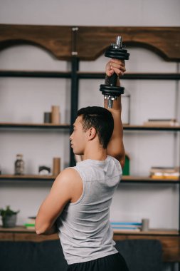 oturma odasında dumbbell ile egzersiz güçlü bı ırkçı adam 