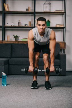 yakışıklı karışık yarış adam egzersiz spor şişe yakınındaki dumbbells ile 