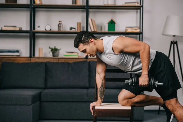 Tattooed Racial Man Doing Exercise Dumbbell Chair Living Room — Stock Photo, Image