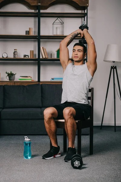 Tattooed Racial Man Holding Dumbbell Head While Sitting Chair Living — Stock Photo, Image