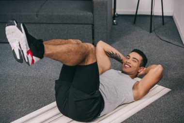 yandan karışık yarış adam dövme ile gülümseyen fitness eğitim mat