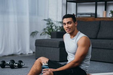 ev jimnastik spor şişe ile oturan mutlu bı ırkçı adam 