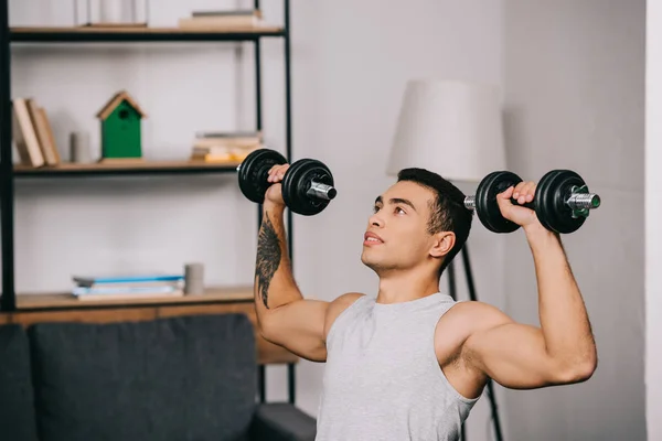 Forte Desportista Misto Segurando Halteres Pesados Exercendo Sala Estar — Fotografia de Stock