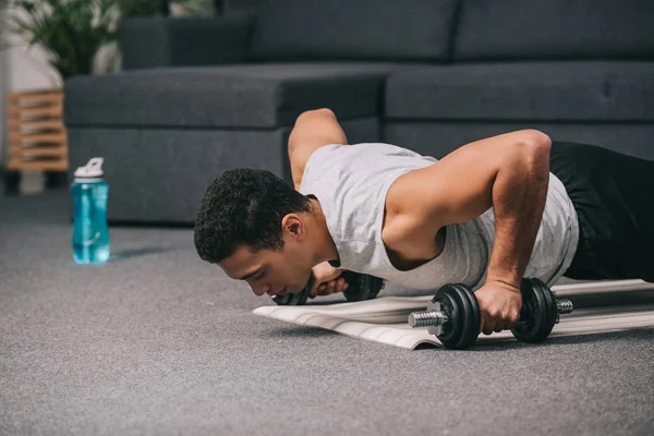 Homem Raça Mista Fazendo Flexões Com Halteres Tapete Fitness Sala — Fotografia de Stock