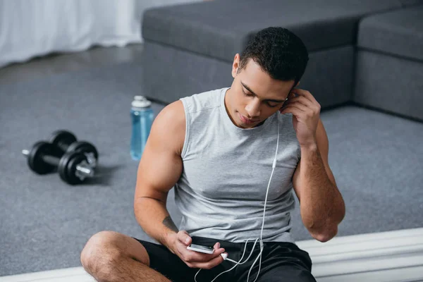 Selektywny Fokus Rasowe Człowieka Pomocą Smartfona Słuchanie Muzyki Siedząc Fitness — Zdjęcie stockowe