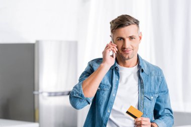 smartphone üzerinde konuşmak ve kredi kartı tutan adam gülümseyen 
