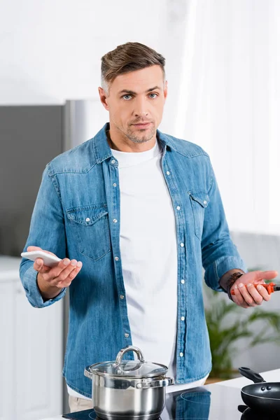Handsome Man Holding Smartphone Looking Camera While Standing Kitchen — Stock Photo, Image