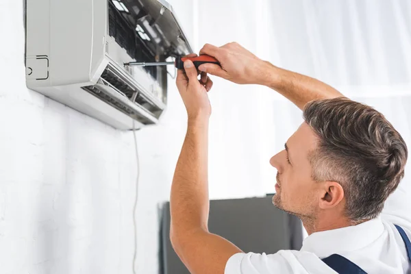 Schöner Erwachsener Mann Repariert Klimaanlage Mit Schraubenzieher — Stockfoto