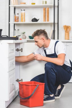kırmızı plastik kova ve evye onarım somun anahtarı ile yetişkin tamirci