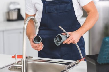mutfak musluk tamiri sırasında borular ve araçları tutarak tamirci kırpılmış görünümünü 