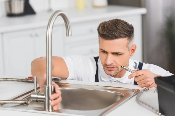 Adulto Reparador Segurando Tubo Chave Durante Reparação Torneira Cozinha — Fotografia de Stock