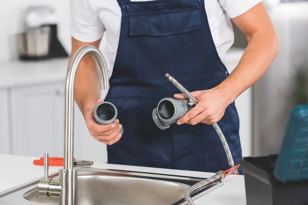 Vista Cortada Reparador Segurando Tubos Ferramentas Durante Reparação Torneira Cozinha — Fotografia de Stock