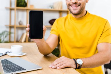 Akıllı telefonu boş ekran ile tutan adamın kırpılmış görüntüsü 