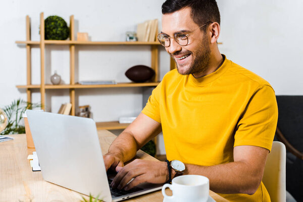 handsome man smiling while using laptop 