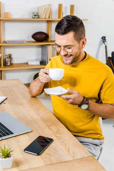 Lächelnder Mann Mit Brille Der Auf Eine Tasse Kaffee Blickt — Stockfoto