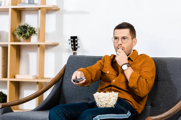 Bel Homme Assis Sur Canapé Tenant Télécommande Mangeant Pop Corn — Photo