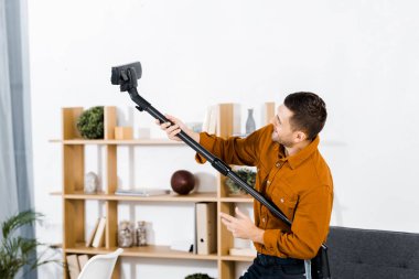 hoover kadar yükselen modern oturma odasında yakışıklı adam
