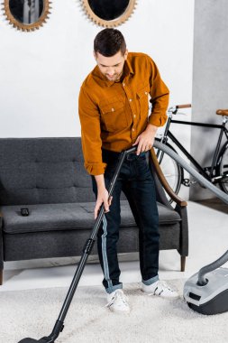 hoover ile temizlik modern oturma odasında yakışıklı adam